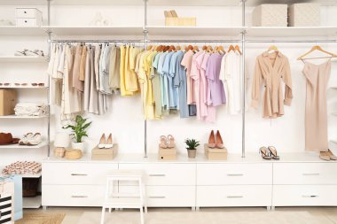 Şık kadın kıyafetleri ve ayakkabıları olan bir butiğin içinde.