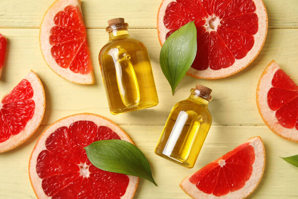 Grapefruit essential oil on yellow wooden background