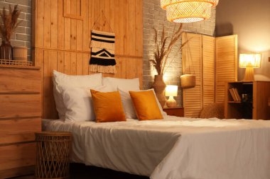 Yatak, otlar ve yatak odasının içinde parlayan lamba.