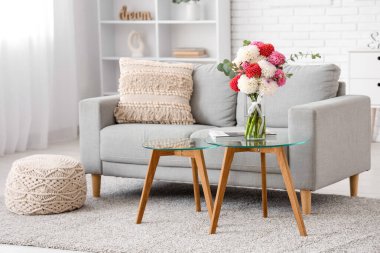 Aydınlık oturma odasının içinde çok güzel yıldız çiçekleri olan vazo.