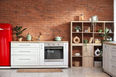 Buzdolabı, fırın ve raf üniteli şık bir mutfak.