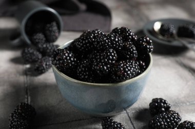 Gri kaplamalı, olgun böğürtlenli kase, yakın plan.