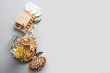 Tahta yuvarlak dilim, papatya çiçeği, kepçe ve kavanoz beyaz arka planda deniz tuzu