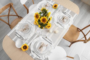 Tabaklarla servis edilen zarif masa, katlanmış peçeteler ve güzel ayçiçekleri, üst manzara.