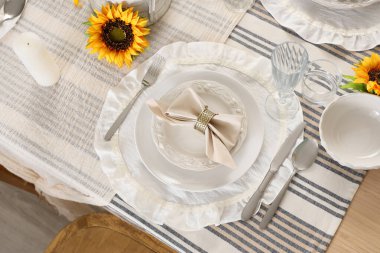 Tabaklarla servis edilen zarif masa, katlanmış peçete ve güzel ayçiçeği, yakın plan.