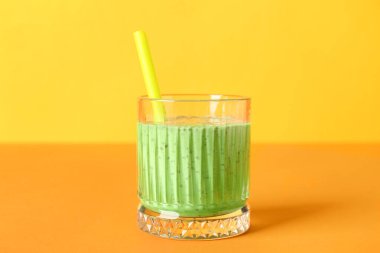 Renkli arkaplanda bir bardak yeşil smoothie