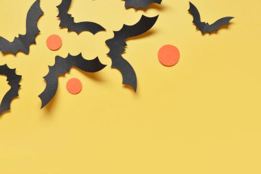 Sarı arka planda Cadılar Bayramı partisi için kağıt yarasalar