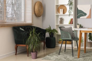 Modern oturma odası, siyah kanepe, masa ve raf ünitesi.