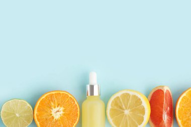 Gerekli yağ şişesiyle kompozisyon ve renk arkaplan üzerinde farklı turunçgil meyveleri