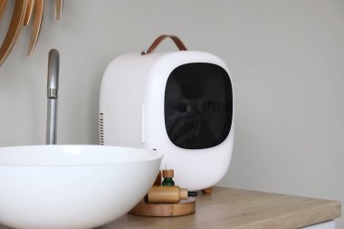 İçinde ürünler olan kozmetik buzdolabı ve banyo çekmecesinde lavabo.