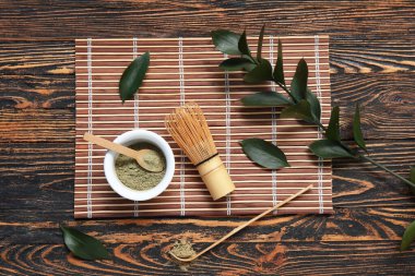 Tahta arka planda Chasen ve Chashaku ile bir kase kibrit tozu.