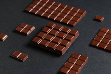 Koyu arkaplanda lezzetli çikolata parçaları olan kompozisyon