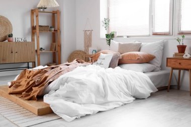 Yatak odasının içi, büyük yatak odası, çekmeceler, raf ünitesi ve komodinli.