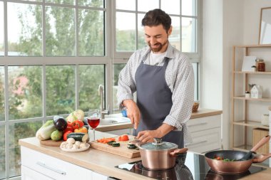 Mutfakta kabak kesen yakışıklı sakallı adam.