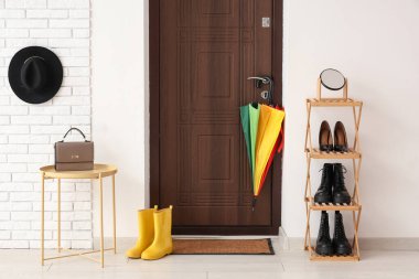 Paspası, şemsiyesi ve ayakkabı standı olan modern koridorun içi.