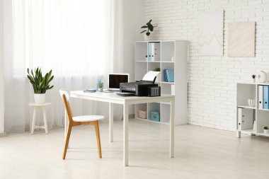Modern yazıcı ve dizüstü bilgisayarı olan şık bir iş yeri