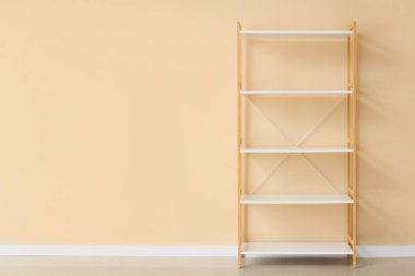 Bej duvarın yanında boş beyaz kitaplık