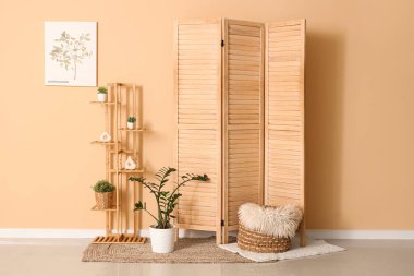 Raflar, ev bitkileri ve ahşap perdeli şık bir oda.