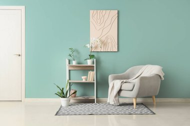 Koltuğu, raf ünitesi ve boyası olan şık bir oturma odası.