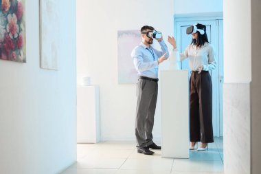 Sanat galerisindeki serginin yakınında VR gözlüklü genç bir çift.