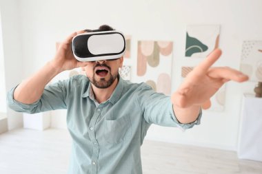 Modern sanat galerisinde VR gözlük kullanan genç adam şok oldu.