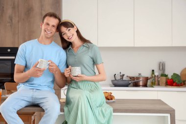 Mutfaktaki masada kahve içen genç bir çift.