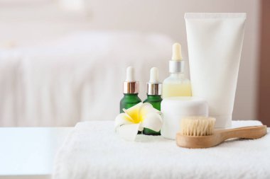 Masada kozmetik ürünler, masaj fırçası ve havlu var.