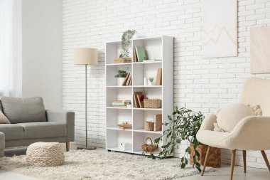 Kitaplık, kanepe ve bitkilerle dolu bir oturma odası.