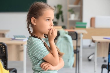 Sınıfta tırnak yiyen küçük bir kız.