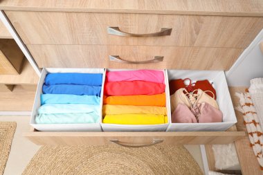 Dolabında organize giysiler olan açık çekmece, üst manzara