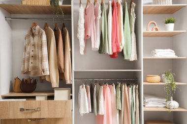 Dolapta raflar, çekmece ve giysiler var.