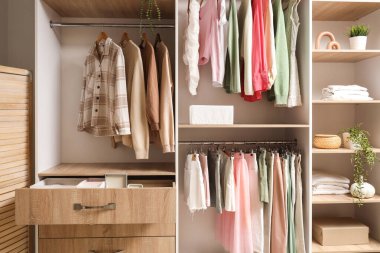 Dolapta çekmeceler ve asılı giysiler var.