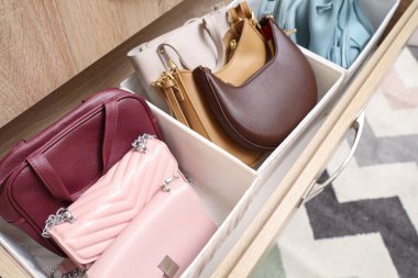 Dolapta organize çantalar olan açık çekmece, yakın plan.