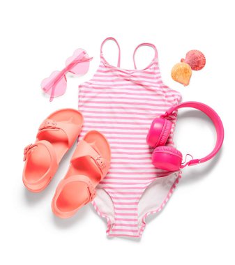 Beyaz arka planda plaj aksesuarları olan çocuk mayosu.