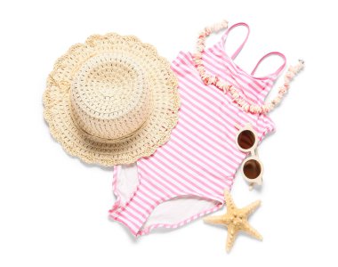 Beyaz arka planda plaj aksesuarları olan çocuk mayosu.