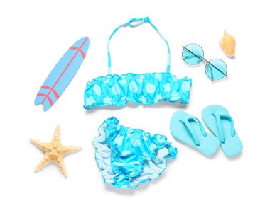 Beyaz arka planda plaj aksesuarları olan çocuk mayosu.