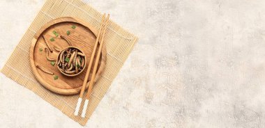 Tahta kase, kızarmış kurtçuklar ve hafif arka planda yemek çubukları. Mesaj için yer var.