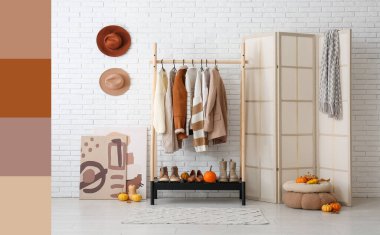 Koridorun içinde sonbahar kıyafetleri, katlanan ekran ve balkabakları var.