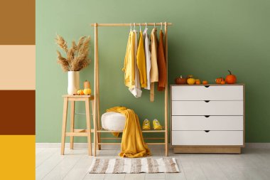 Koridorun içinde sonbahar kıyafetleri, çekmeceler ve balkabakları var.