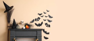 Cadılar Bayramı için bej duvarın yanında şömine rafı süslenmiş. Tasarım için pankart