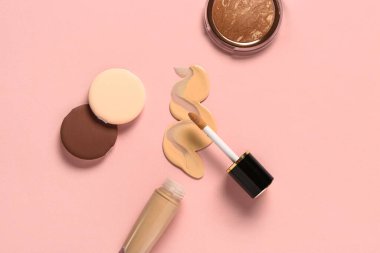 Örnek, fosforlu ve pembe arka planda süngerli bir şişe makyaj malzemesi.