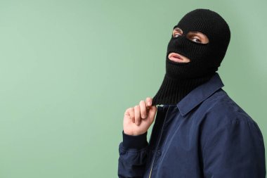 Yeşil arka planda kar maskeli yakışıklı bir genç.