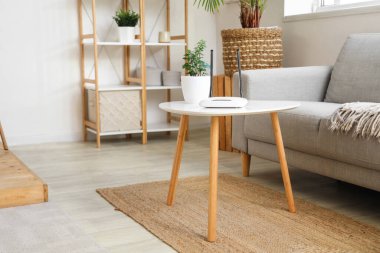 Modern Wi-Fi yönlendirici. Oturma odasındaki masada bitki var.