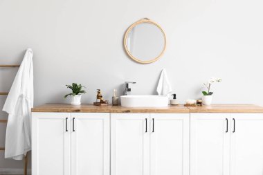 Modern lavabo, banyo malzemeleri çekmecelerde ve banyodaki ışık duvarında ayna.