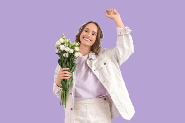 Kulaklıklı güzel bir genç kadın. Leylak arka planında Eustoma çiçekleri var.