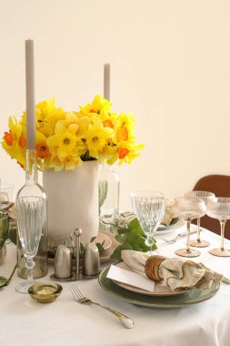 Düğün kutlaması için nergis ve mumlarla dolu güzel bir masa.