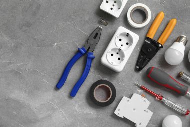 Gri grunge arka planda elektrikçi aletleri, ampuller ve soketler