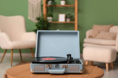 Odadaki sehpanın üzerinde diski olan bir plak çalar.