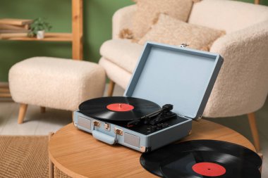 Odadaki sehpanın üzerinde diskleri olan bir pikap.