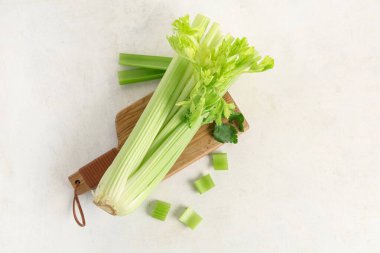 Beyaz zemin üzerinde taze yeşil kereviz demeti ile ahşap tahta tahta